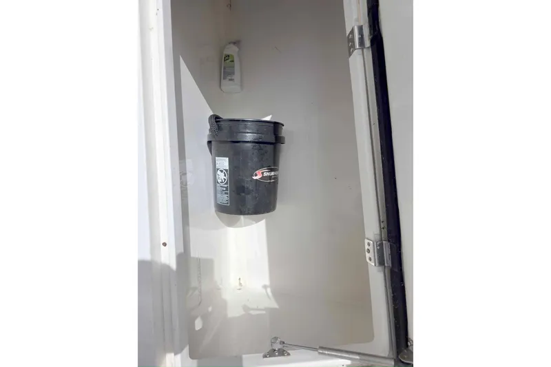 Slide: The Image of Storage compartment on a 2008 Intrepid 430 Sport Yacht with a black bucket and cleaning supplies. - 61