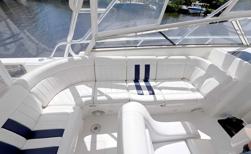 Slide: The Image of 2008 Intrepid 430 Sport Yacht interior with white and blue seating, overlooking water. - 8