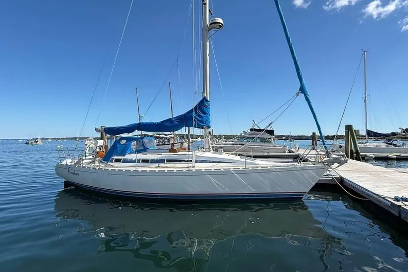 The Image of 1985 Beneteau First 375 sailboat docked in a marina under clear blue skies. - 0