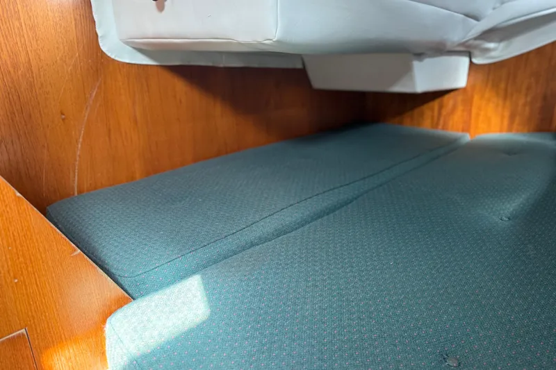 Slide: The Image of Interior cabin of 1985 Beneteau First 375 sailboat with green cushions and wooden paneling. - 10