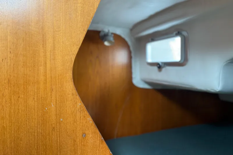 Slide: The Image of Interior cabin view of 1985 Beneteau First 375 sailboat, featuring wood paneling and a small window. - 11