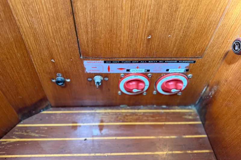Slide: The Image of Control panel of a 1985 Beneteau First 375 sailboat with red switches and wood finish. - 12