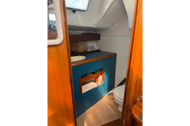 Slide: The Image of Interior of 1985 Beneteau First 375 sailboat, featuring compact bathroom and wooden accents. - 13