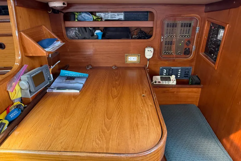 Slide: The Image of Navigation station of 1985 Beneteau First 375 sailboat with wooden desk and electronic equipment. - 14