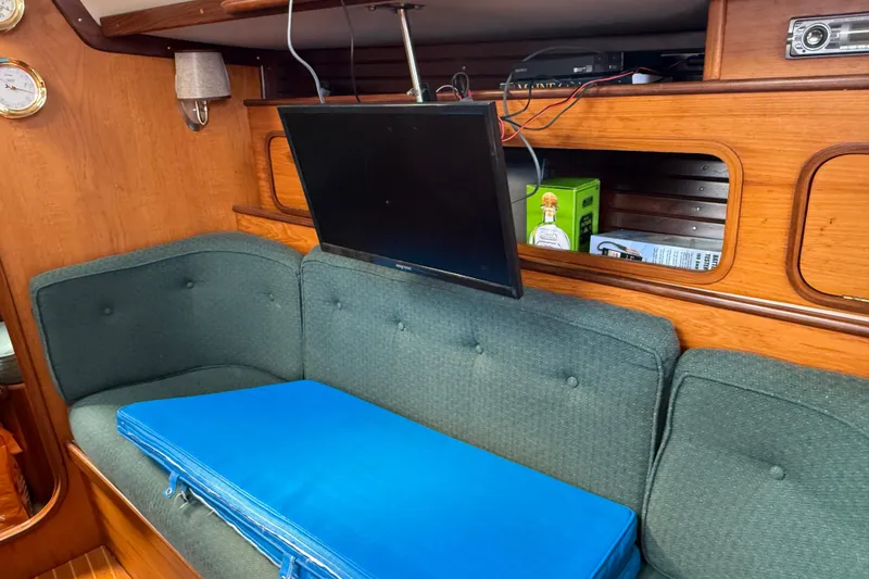 Slide: The Image of Interior of 1985 Beneteau First 375 yacht with TV and green seating. - 16
