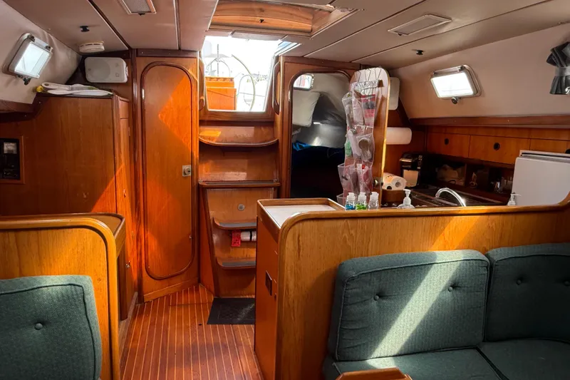 Slide: The Image of Interior of 1985 Beneteau First 375 sailboat, featuring wood paneling and cozy seating area. - 19