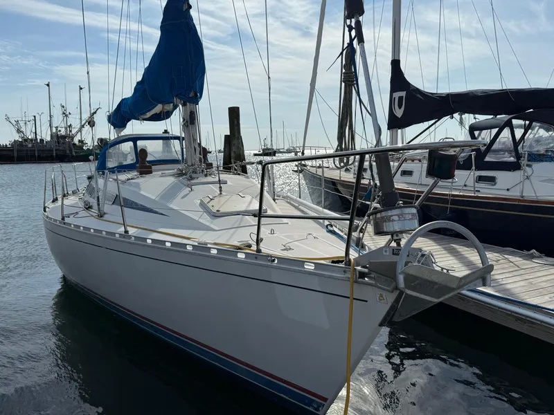 Slide: The Image of 1985 Beneteau First 375 sailboat docked in a marina under a clear sky. - 2