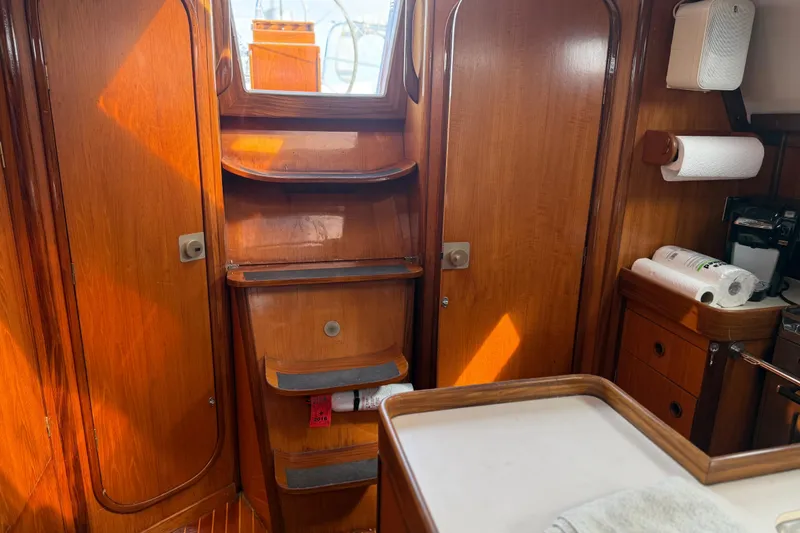 Slide: The Image of Interior of 1985 Beneteau First 375 sailboat with wooden cabinetry and storage shelves. - 27