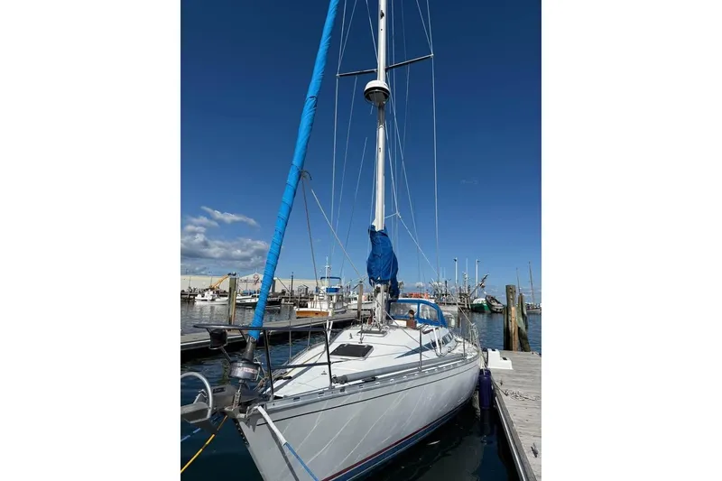 Slide: The Image of 1985 Beneteau First 375 sailboat docked at marina under clear blue sky. - 28