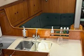 Slide: The Image of 1985 Beneteau First 375 yacht interior with kitchen sink and seating area. - 7