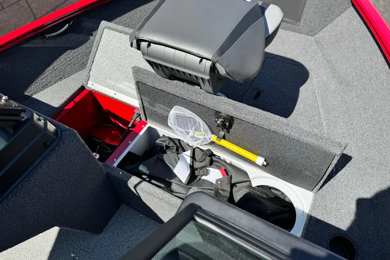 Slide: The Image of 2024 Lund 1650 Rebel XL Sport boat interior with storage compartments and fishing gear. - 10