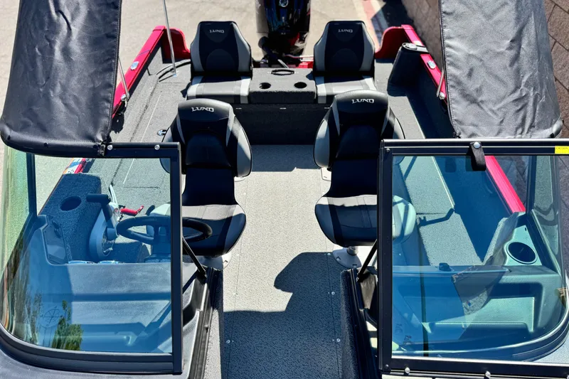 Slide: The Image of 2024 Lund 1650 Rebel XL Sport boat interior with seating and steering console. - 11
