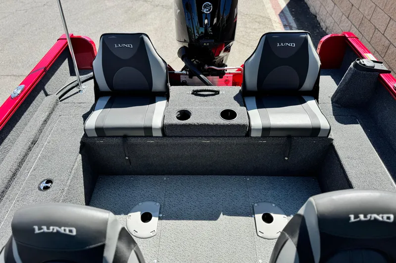 Slide: The Image of 2024 Lund 1650 Rebel XL Sport boat interior with seating and motor. - 12