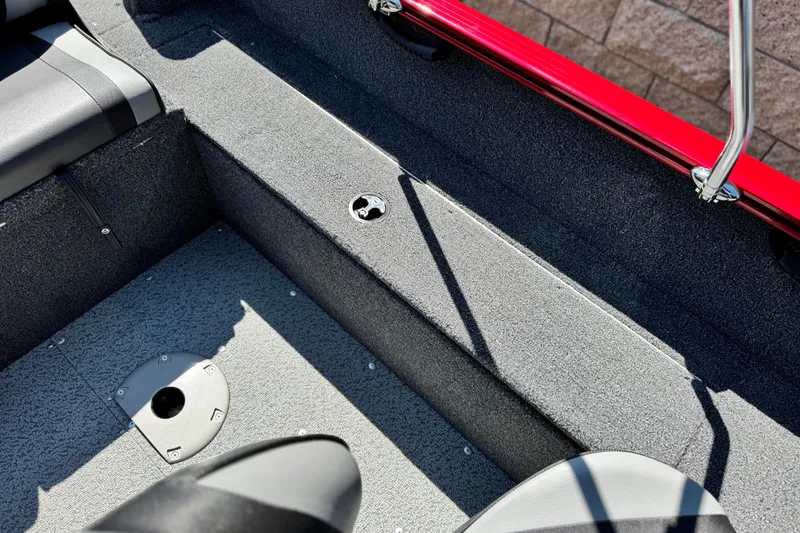 Slide: The Image of 2024 Lund 1650 Rebel XL Sport boat interior with gray carpet and red railing. - 14