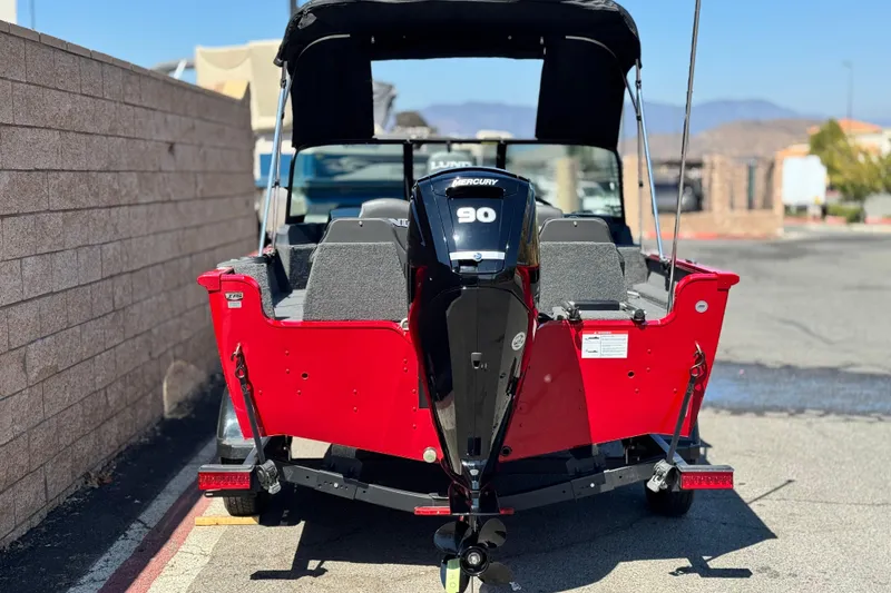 Slide: The Image of 2024 Lund 1650 Rebel XL Sport boat with Mercury 90 engine, parked outdoors. - 4