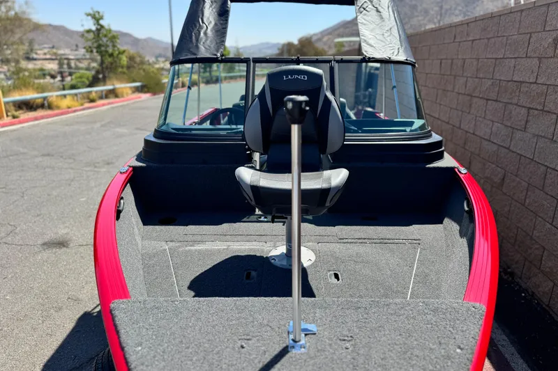 Slide: The Image of 2024 Lund 1650 Rebel XL Sport boat with red trim, parked outdoors. - 7