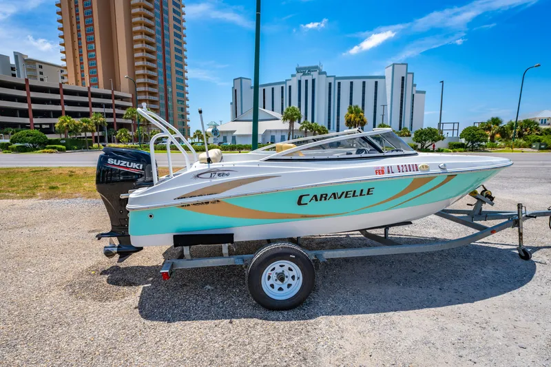 Slide: The Image of 2018 Caravelle 17 EBo Bowrider on trailer, parked near tall buildings. - 2