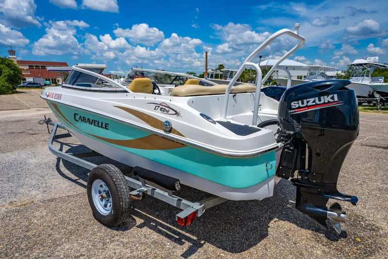 Slide: The Image of 2018 Caravelle 17 EBo Bowrider with Suzuki outboard motor on trailer, under blue sky. - 4