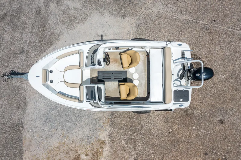 Slide: The Image of 2018 Caravelle 17 EBo Bowrider boat, aerial view, beige seating, parked on concrete. - 5