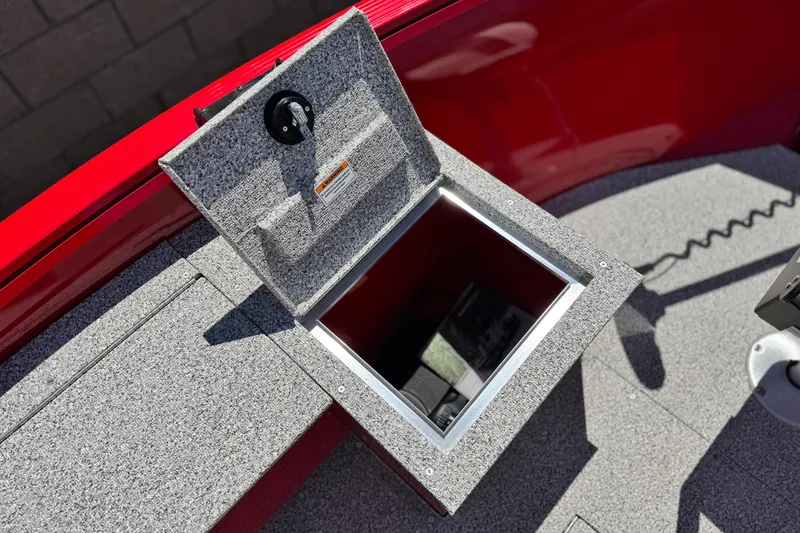 Slide: The Image of Open storage compartment on 2023 Apex Polar Kraft V186 boat, featuring red and gray design. - 13