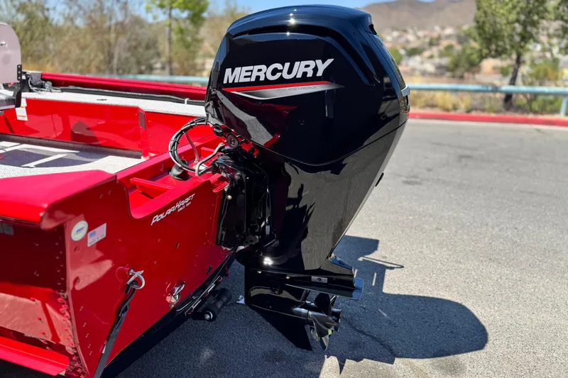 Slide: The Image of 2023 Apex Polar Kraft V186 boat with Mercury outboard motor, red exterior, parked outdoors. - 7
