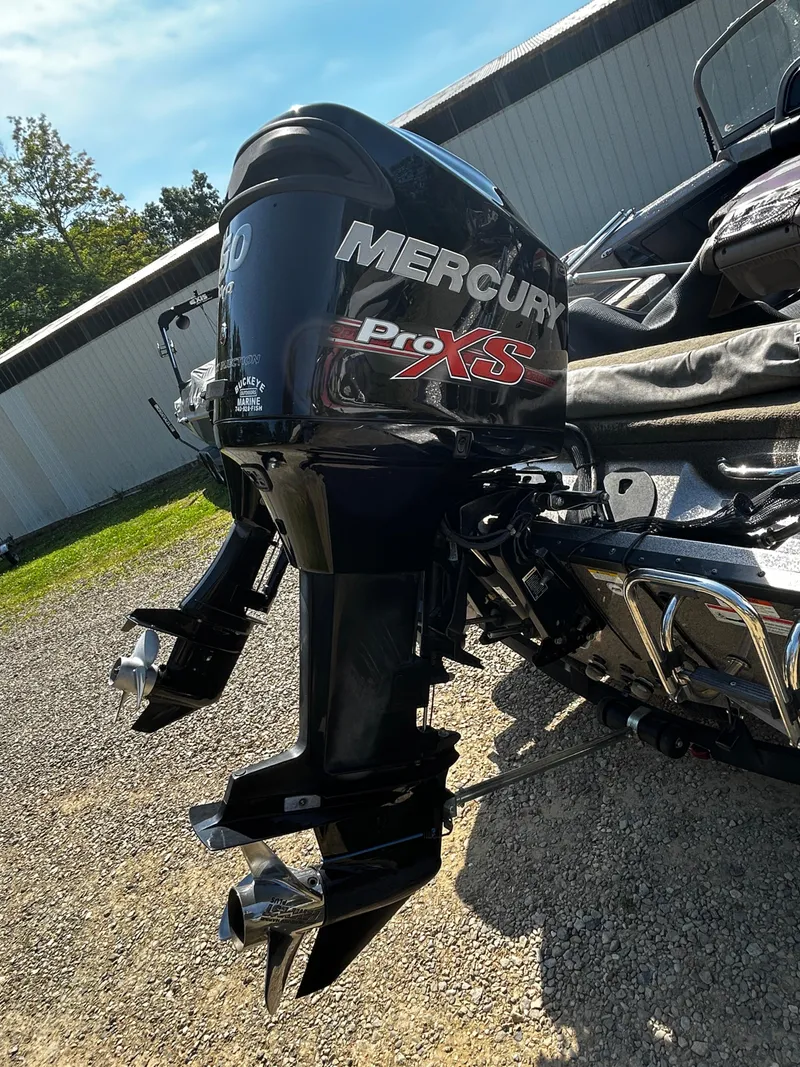 Slide: The Image of 2013 Triton 186 Fishunter with Mercury Pro XS outboard motor, parked outdoors. - 11