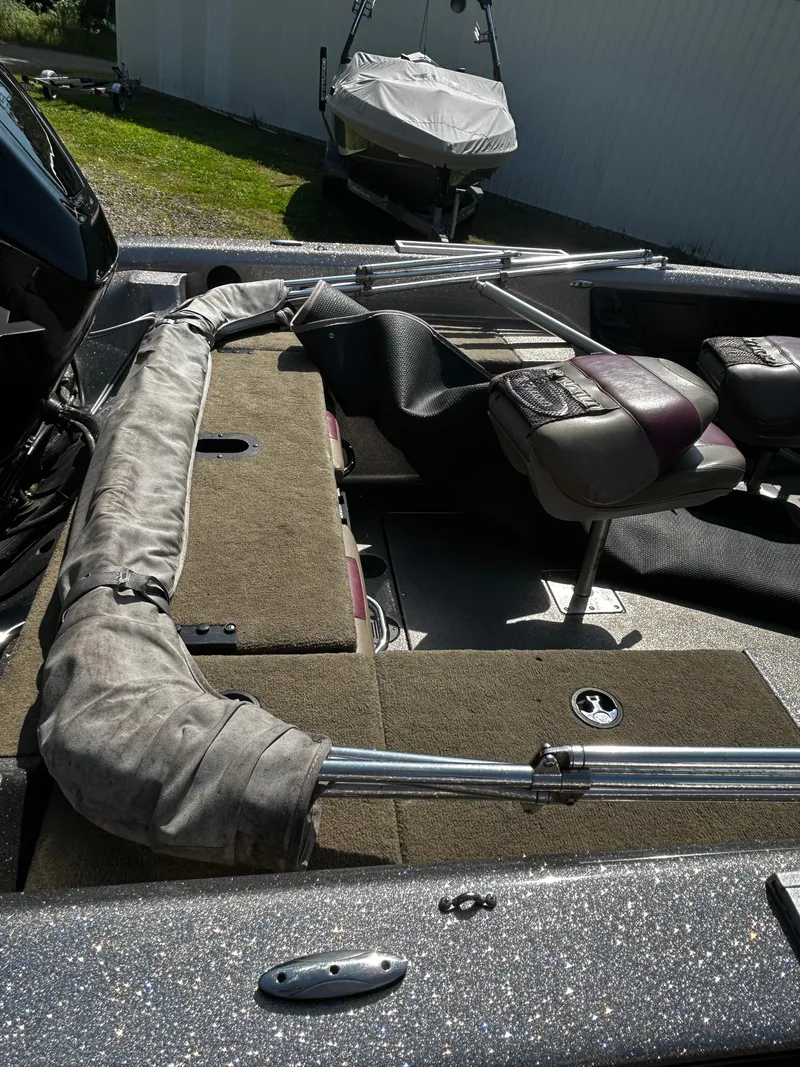 Slide: The Image of 2013 Triton 186 Fishunter boat interior with seating and fishing rod storage. - 2