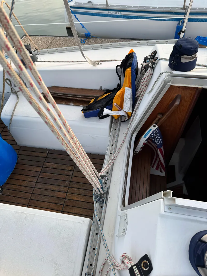 Slide: The Image of 1986 Hunter 28.5 sailboat cockpit with ropes, life jacket, and American flag. - 10
