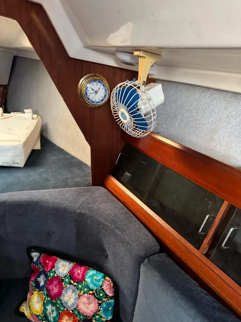 Slide: The Image of Interior of 1986 Hunter 28.5 sailboat with fan, clock, and colorful cushion. - 12