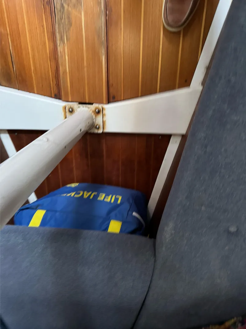 Slide: The Image of Interior of a 1986 Hunter 28.5 sailboat with life jacket and wooden paneling. - 13