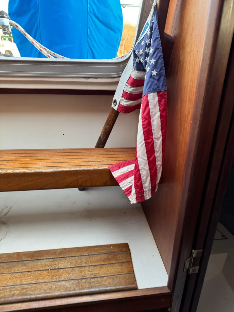 Slide: The Image of American flag on wooden steps inside 1986 Hunter 28.5 sailboat cabin. - 15