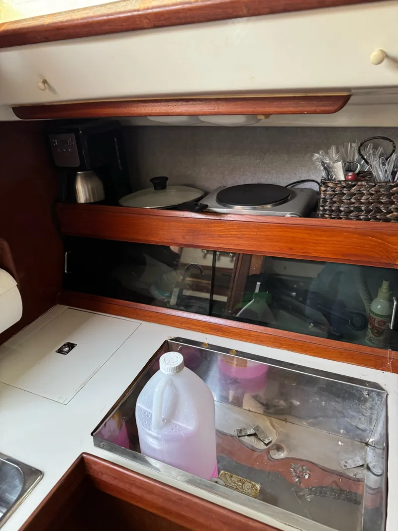 Slide: The Image of 1986 Hunter 28.5 yacht kitchen with stove, utensils, and storage. - 18