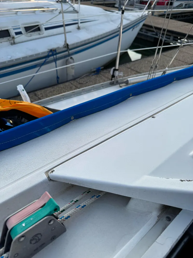 Slide: The Image of 1986 Hunter 28.5 sailboat deck with rigging and docked boats in background. - 20