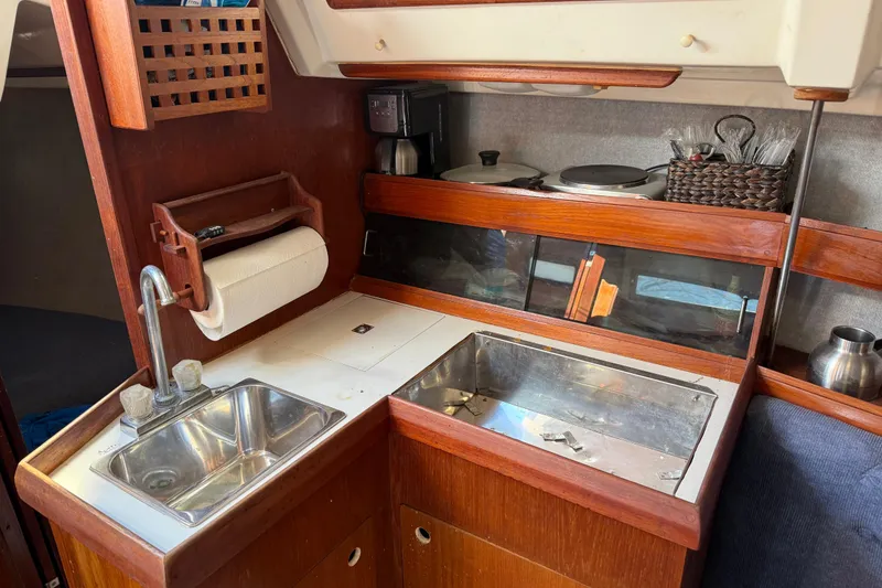 Slide: The Image of Compact kitchen area in a 1986 Hunter 28.5 sailboat with sink and storage. - 25