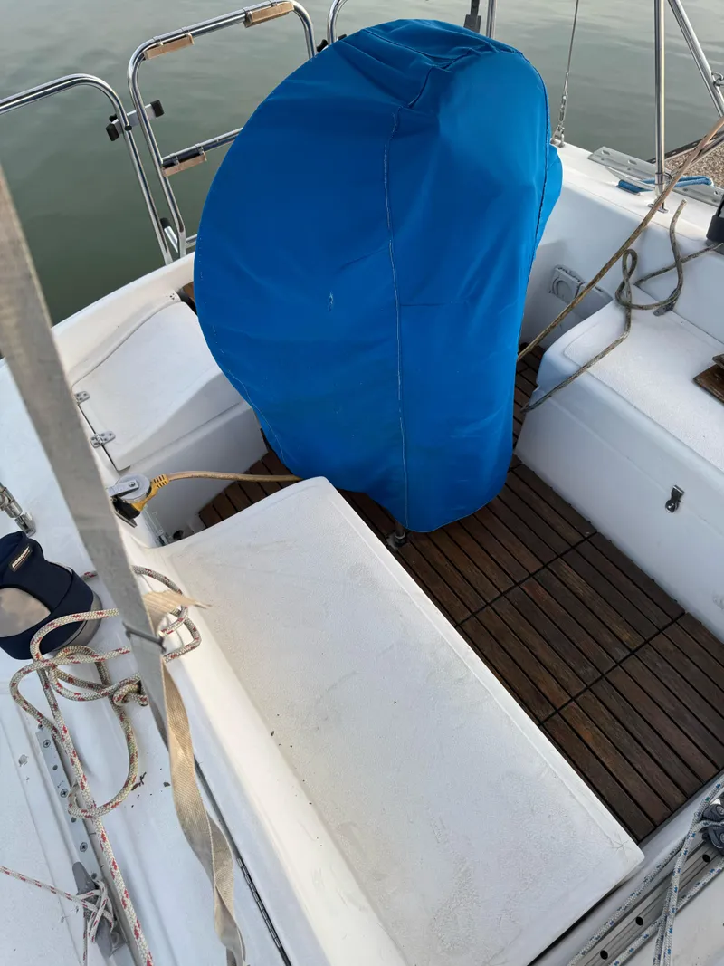 Slide: The Image of Cockpit of 1986 Hunter 28.5 sailboat with blue-covered helm and wooden flooring. - 6