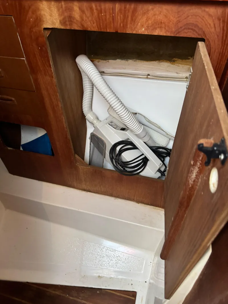 Slide: The Image of 1986 Hunter 28.5 sailboat interior compartment with hoses and wiring. - 7