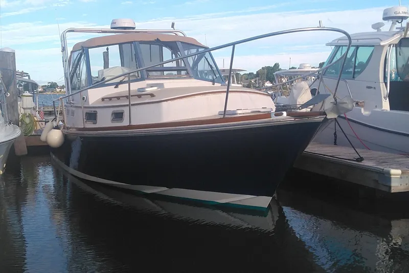 The Image of 1998 Bruckmann BLUESTAR 29 boat docked in a marina, side view. - 1