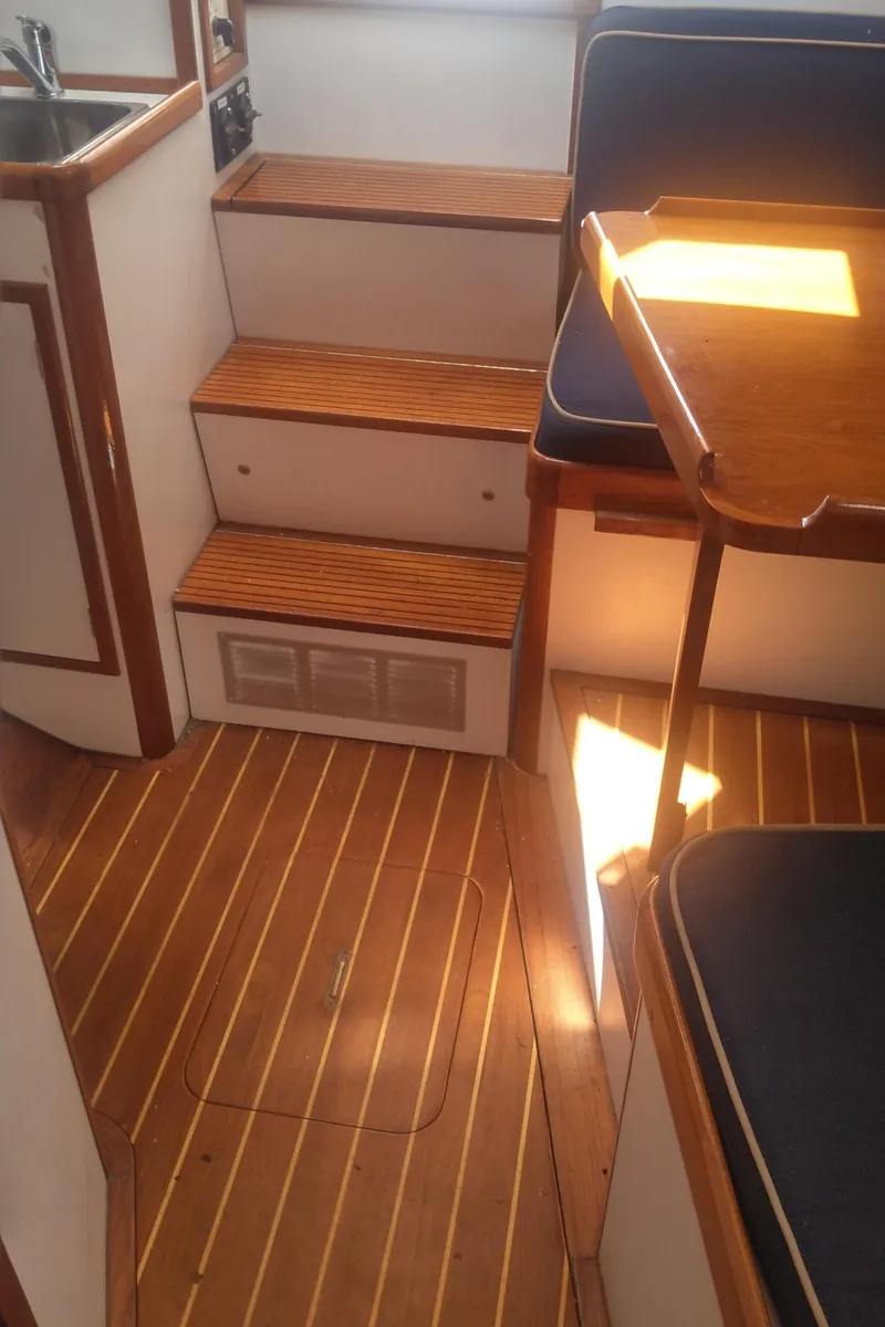 Slide: The Image of Interior of 1998 Bruckmann BLUESTAR 29 boat with wooden flooring and seating. - 12