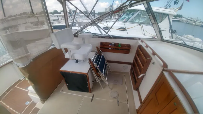 Slide: The Image of 1998 Bruckmann BLUESTAR 29 boat interior with seating and storage at a marina. - 16