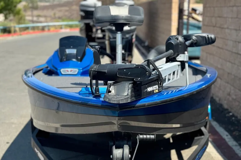 Slide: The Image of 2021 Vexus AVX1980 boat with Minn Kota Ultrex motor, parked outdoors. - 2