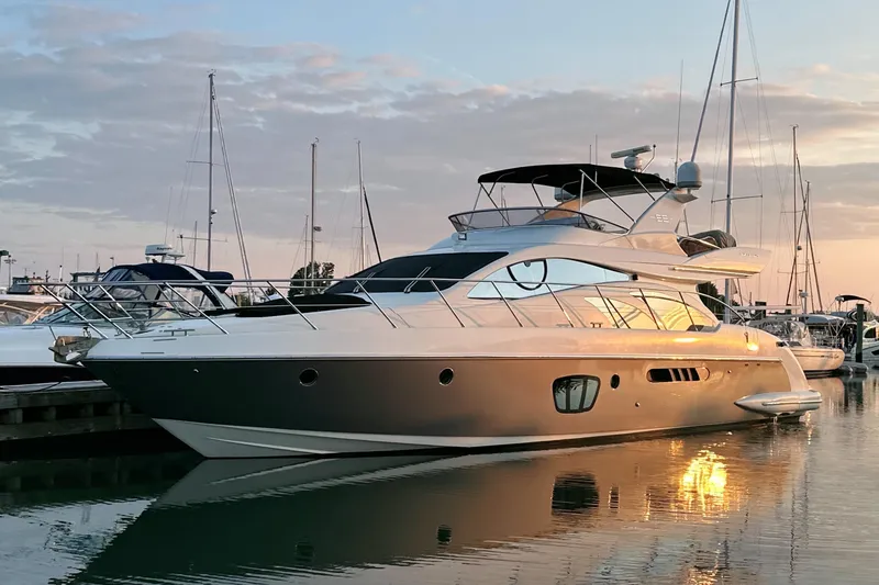 Slide: The Image of Luxurious 2010 Azimut 55E yacht docked at sunset, reflecting on calm water. - 2