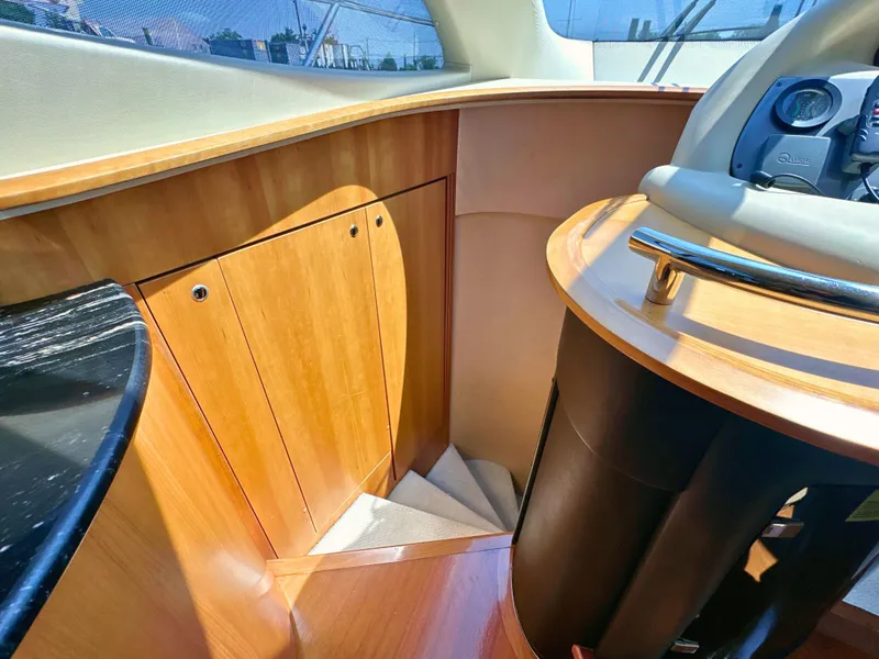Slide: The Image of Interior of 2010 Azimut 55E yacht, featuring wooden cabinetry and helm station. - 20