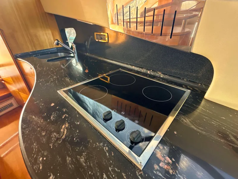 Slide: The Image of Luxurious kitchen area in 2010 Azimut 55E yacht with sleek black countertop. - 25