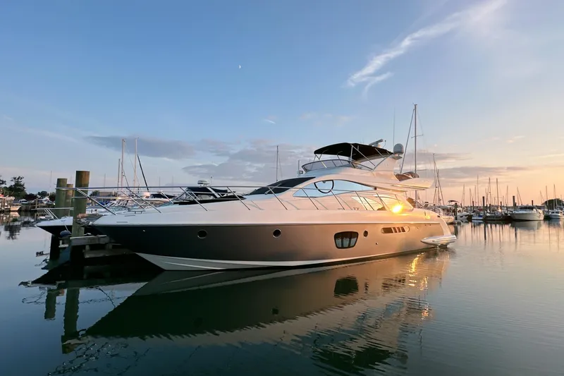 Slide: The Image of Luxury 2010 Azimut 55E yacht docked at sunset in a serene marina. - 3