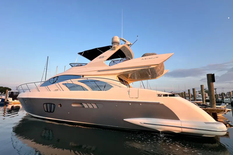 Slide: The Image of Luxury 2010 Azimut 55E yacht docked at sunset, showcasing sleek design and elegance. - 4