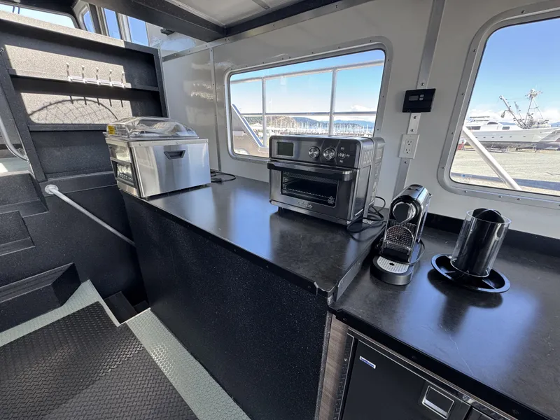 Slide: The Image of Modern kitchen area in a 2020 Aluminum Cruiser 42' Trawler with appliances and scenic window view. - 10