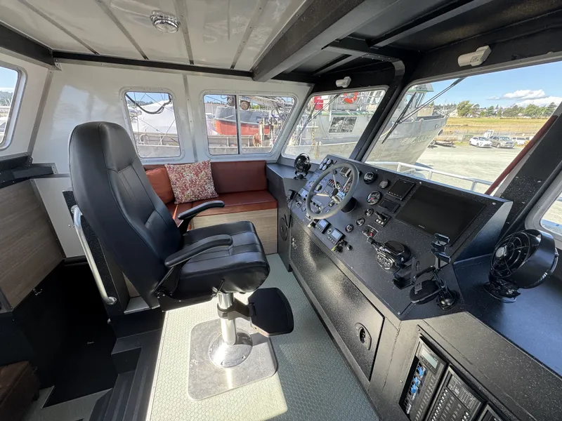 Slide: The Image of Interior of a 2020 Aluminum Cruiser 42' Trawler with helm, seating, and navigation controls. - 14