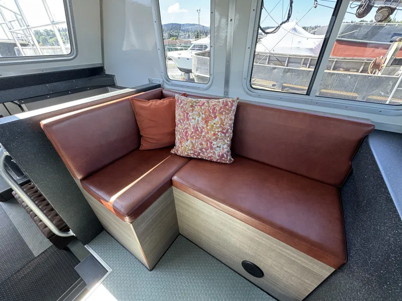 Slide: The Image of Cozy seating area in 2020 Aluminum Cruiser 42' Trawler with brown cushions and decorative pillow. - 20