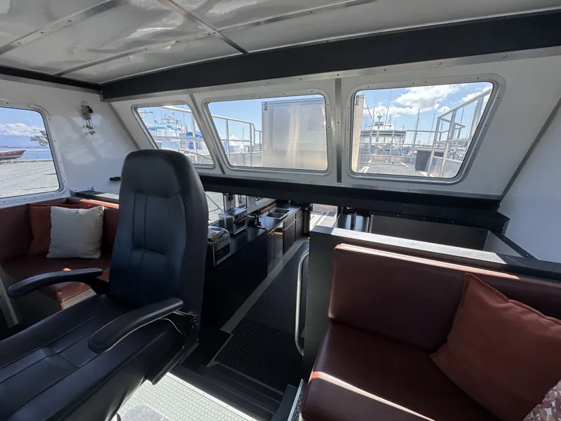 Slide: The Image of Interior of 2020 Aluminum Cruiser 42' Trawler with seating and helm, dock view outside. - 21