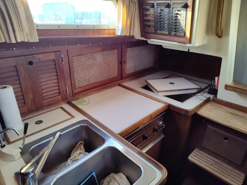 Slide: The Image of 1982 Bristol 35.5 yacht interior kitchen with wooden cabinets and stainless steel sink. - 11